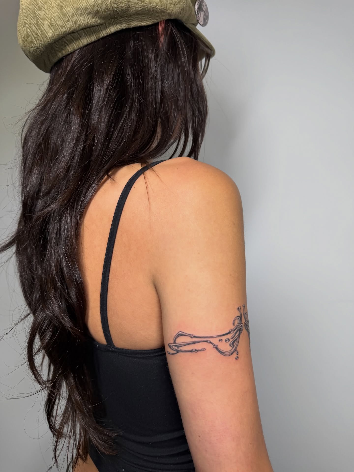 Guitar black and grey tattoo on the upper arm by Lauren ๐