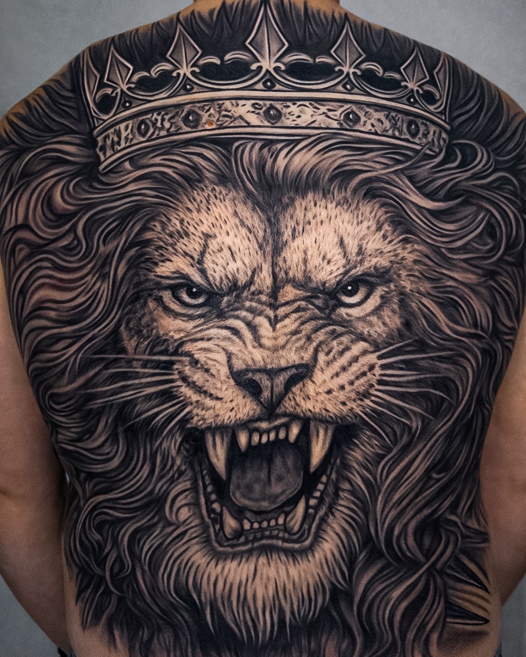 Lion with crown realism tattoo on the back by Mak$ Brand