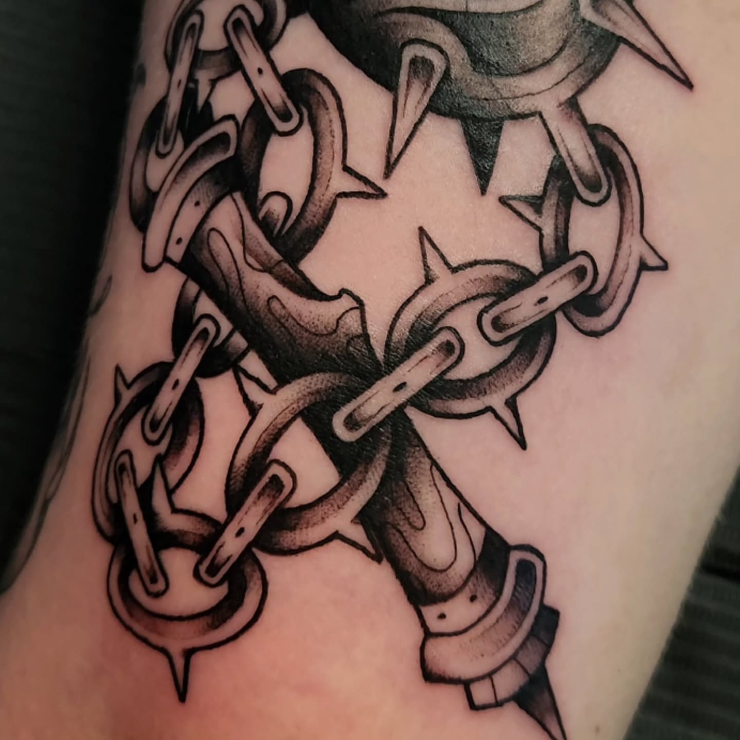 Chains and spikes black and grey tattoo on the forearm by Gavvo