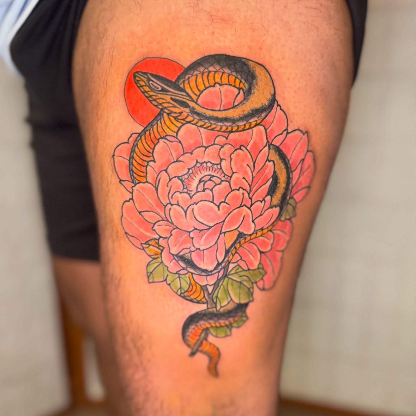 Snake and peony American traditional tattoo on the thigh by Dylan