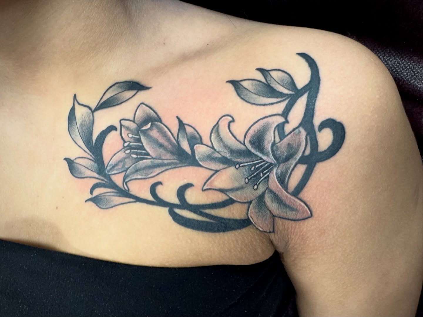 Lilies black and grey tattoo on the shoulder by Samantha Jane