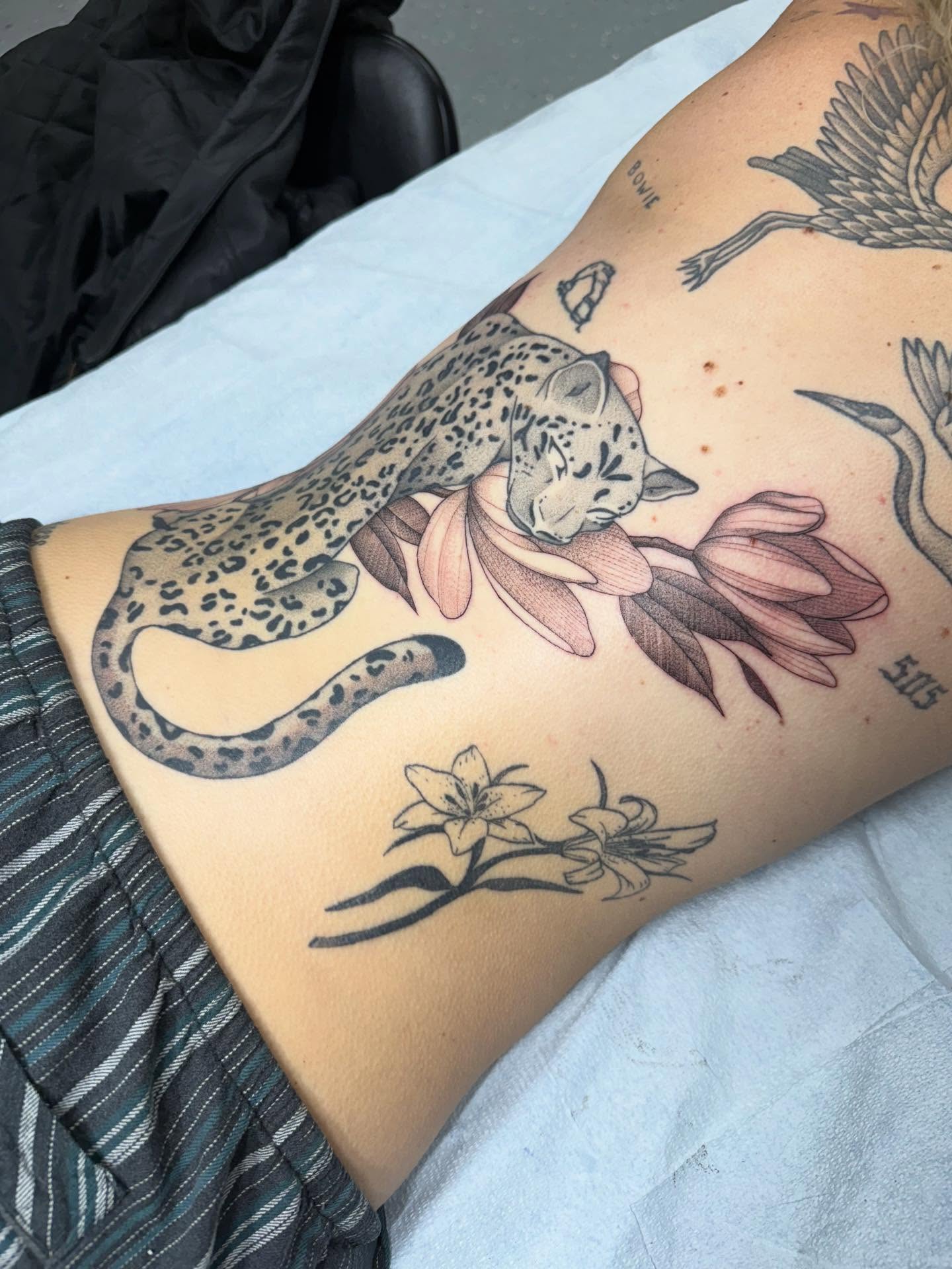 Leopard and flowers realism tattoo on the ribs by Maddie Jo DeYoung