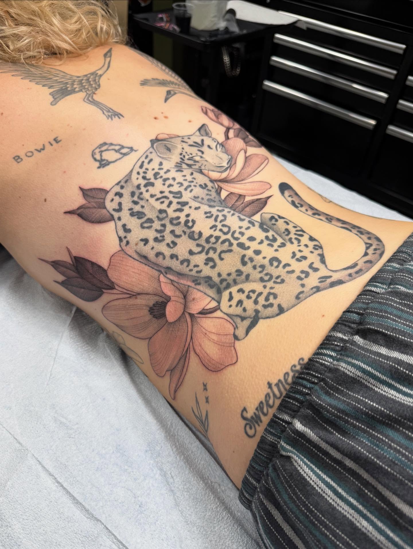 Leopard and flowers realism tattoo on the thigh by Maddie Jo DeYoung