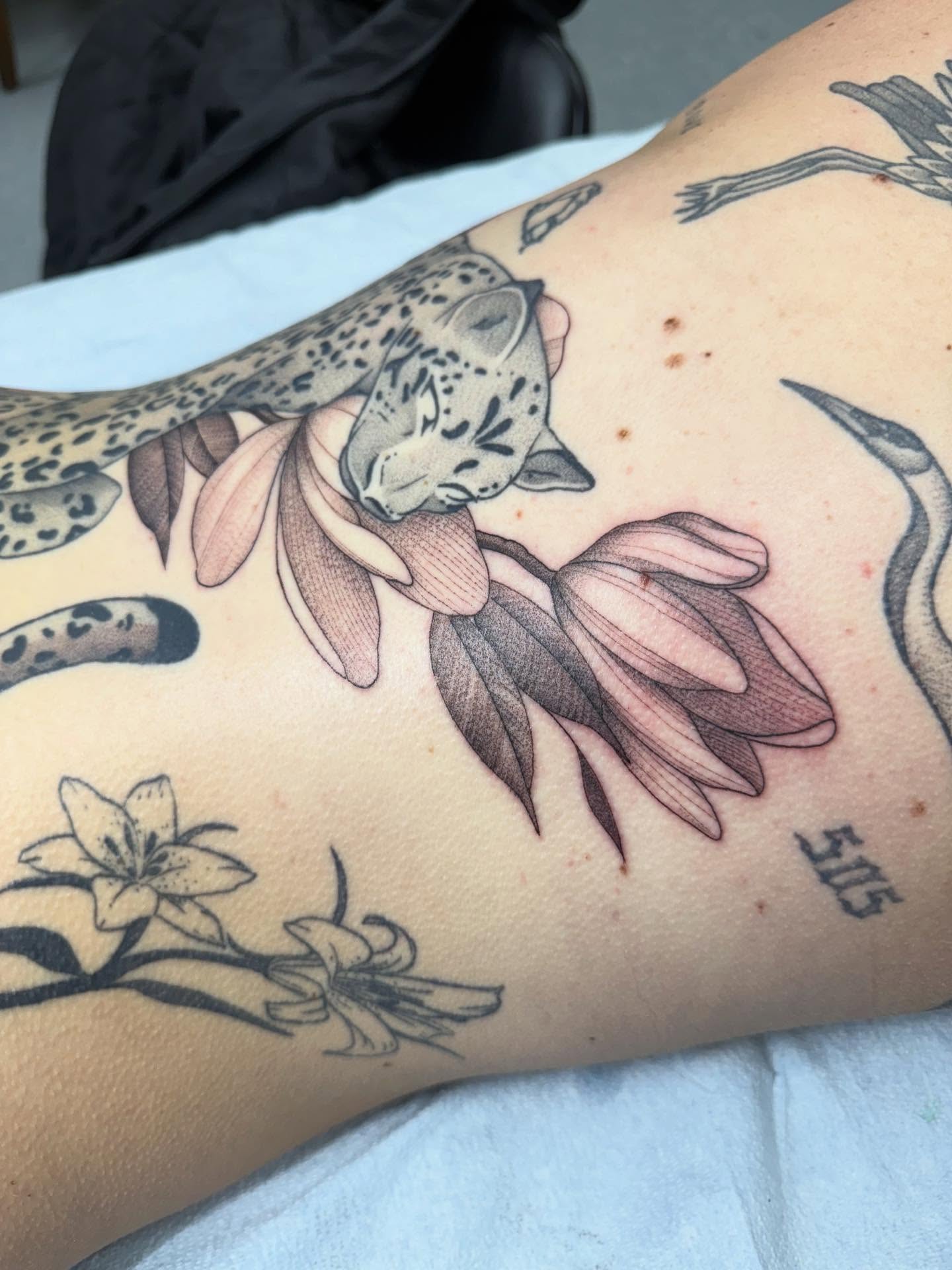 Leopard and flowers realism tattoo on the thigh by Maddie Jo DeYoung