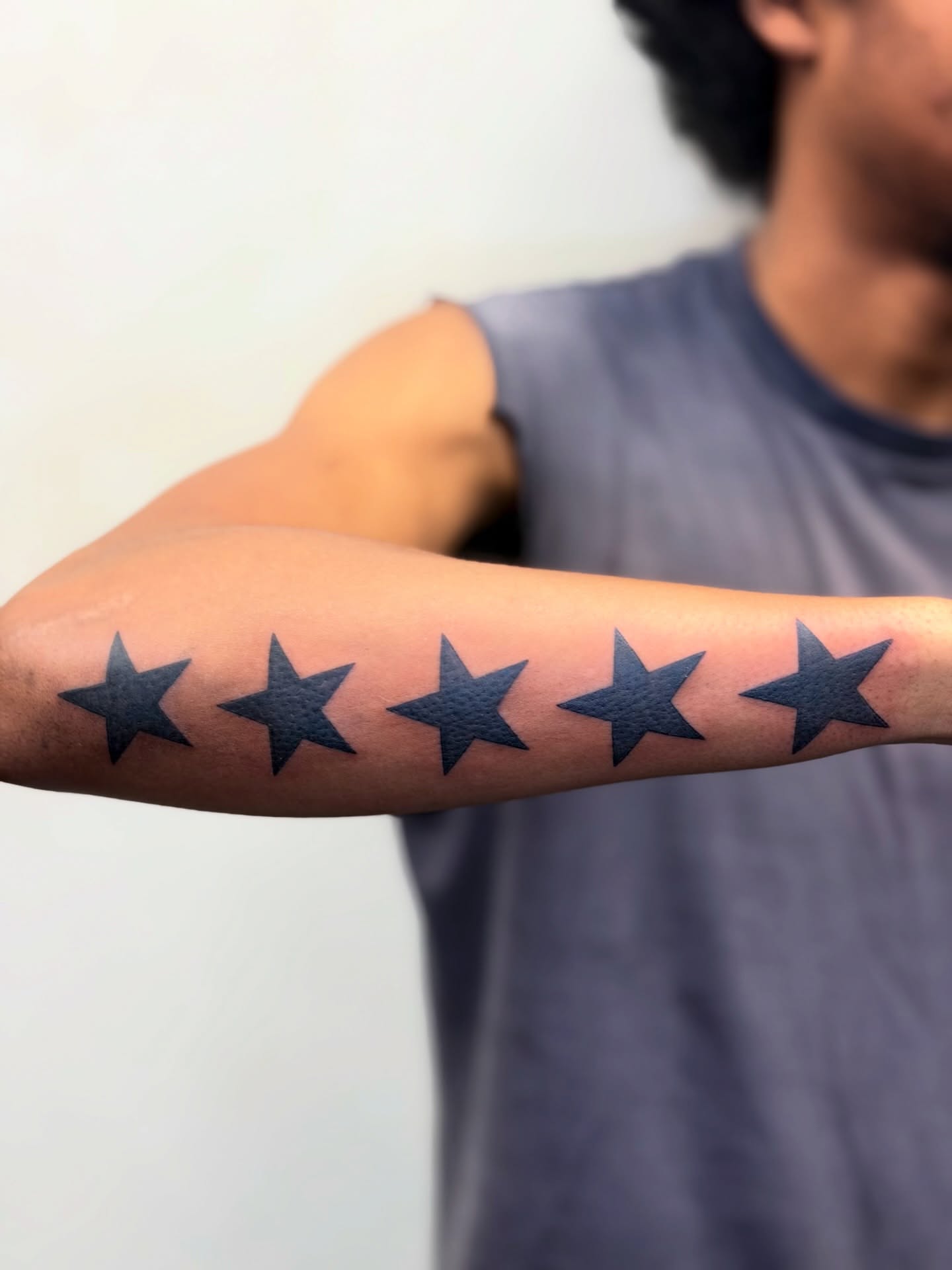 Five-pointed stars black and grey tattoo on the forearm by Bryan Nguyen
