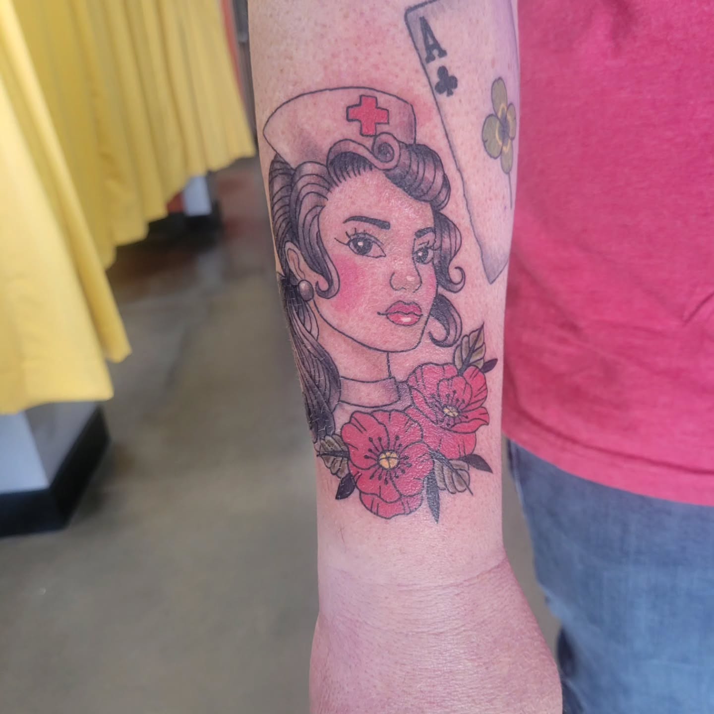 Nurse with flowers American traditional tattoo on the forearm by Aspen C
