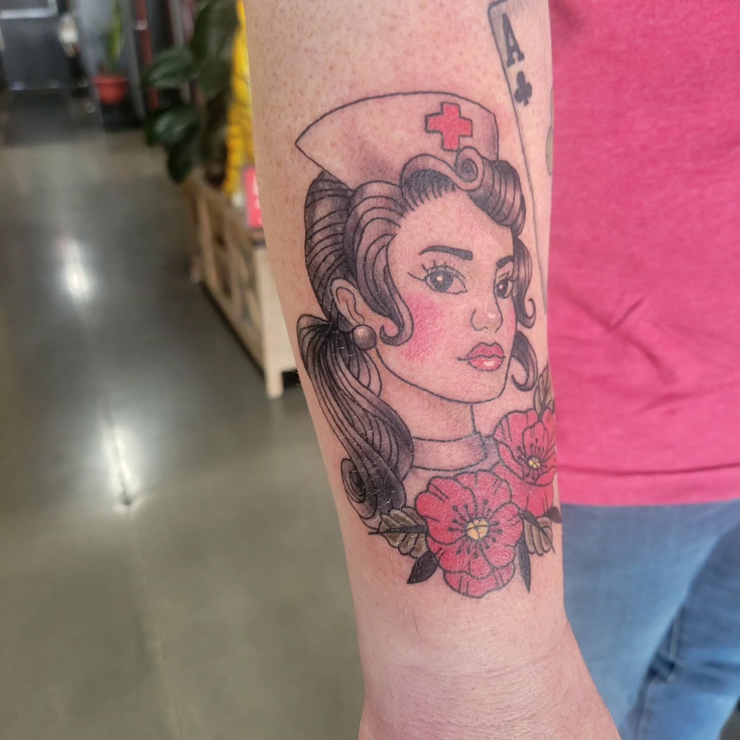 Nurse with flowers American traditional tattoo on the forearm by Aspen C