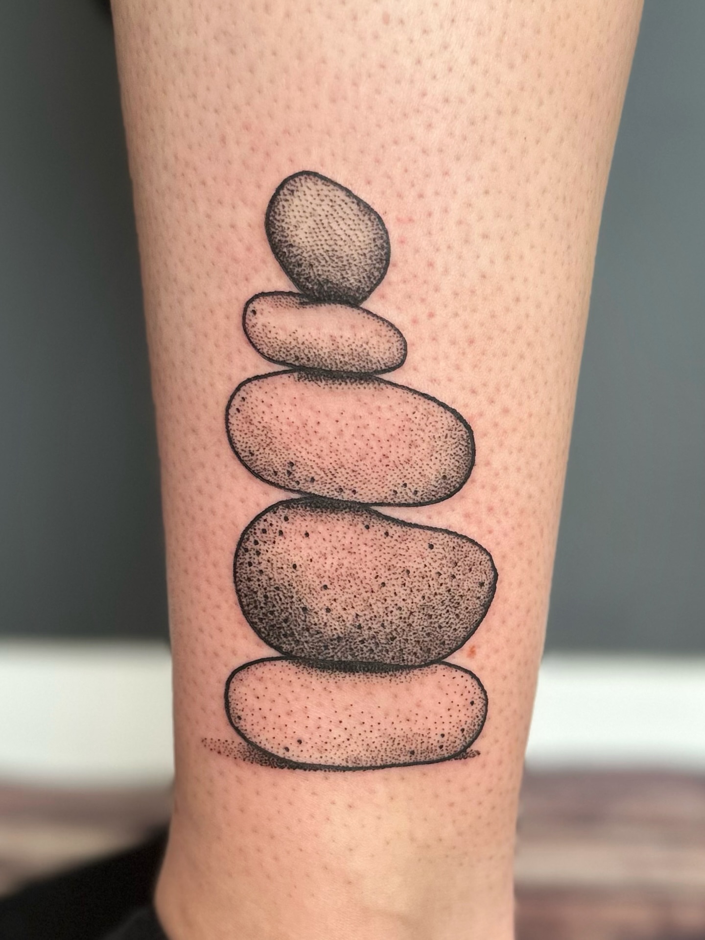 Stacked stones dotwork tattoo on the forearm by Maddie Morrill