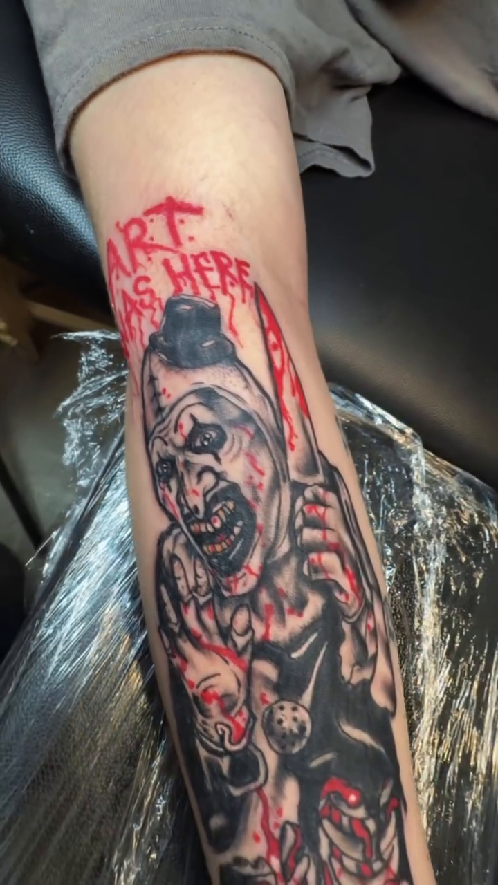 Scary clown with knife and text realism tattoo on the forearm by Chieftats614π₯