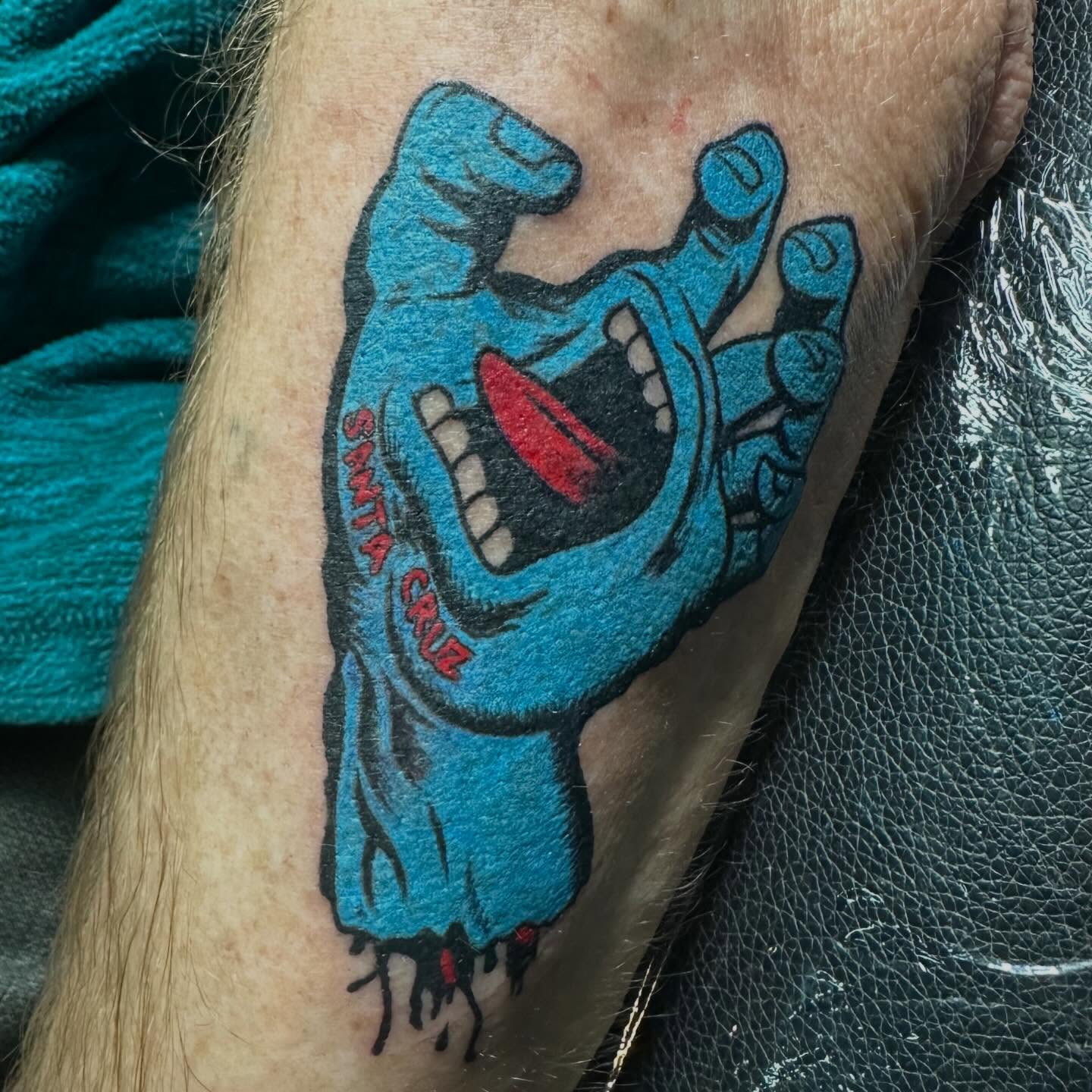 Skateboard hand American traditional tattoo on the forearm by Sarah Nash