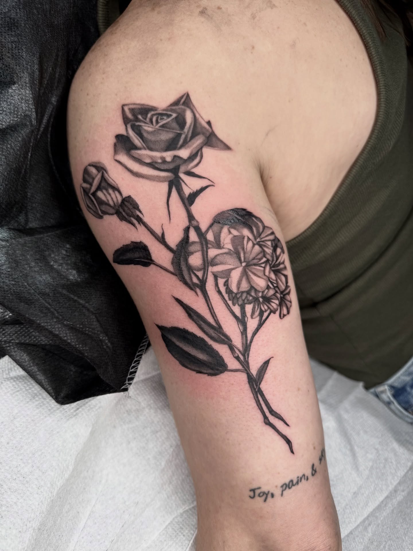 Flower arrangement black and grey tattoo on the forearm by Joe Weber, Monona, Wisconsin