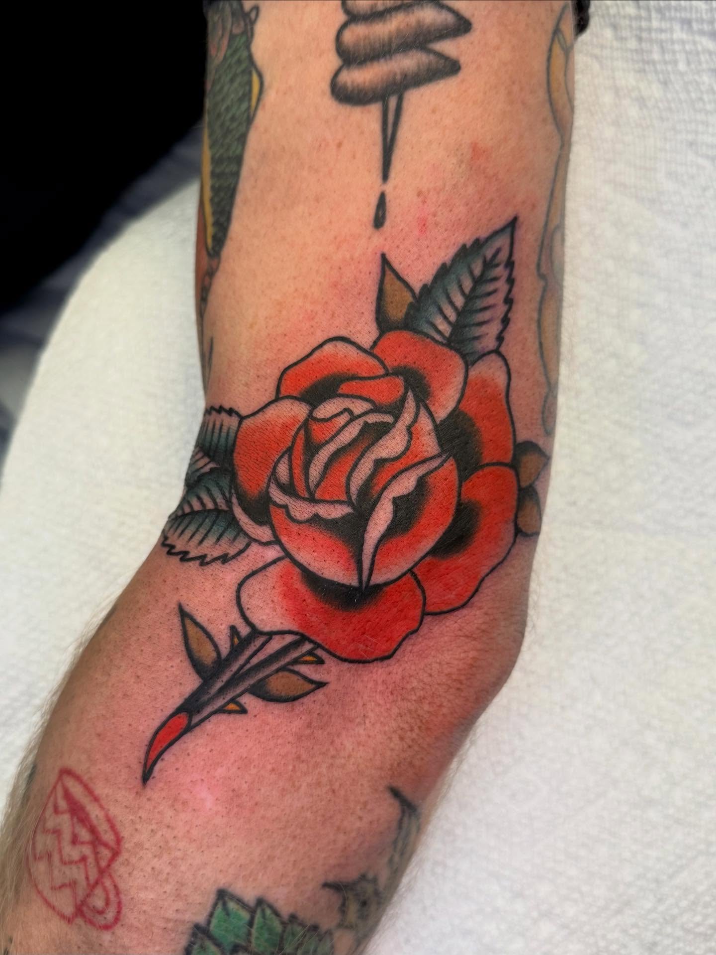 Red rose American traditional tattoo on the forearm by Cody Petkus