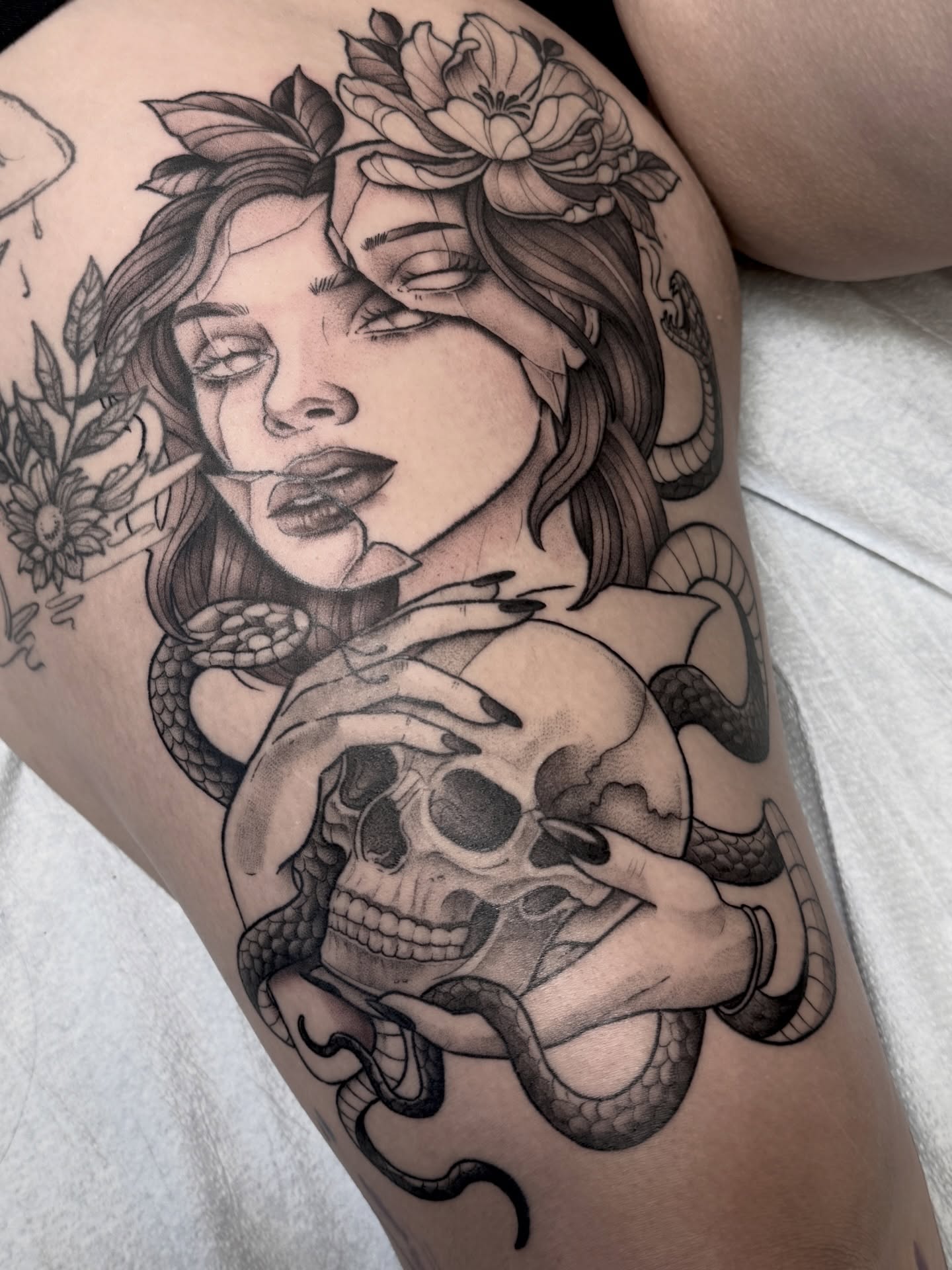 Woman with snake and skull realism tattoo on the thigh by Hannah May, La Mesa, California