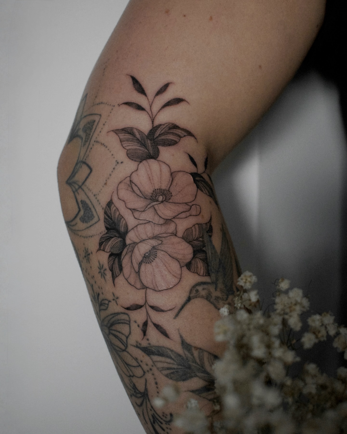 Floral bouquet black and grey tattoo on the forearm by Haley Sayers