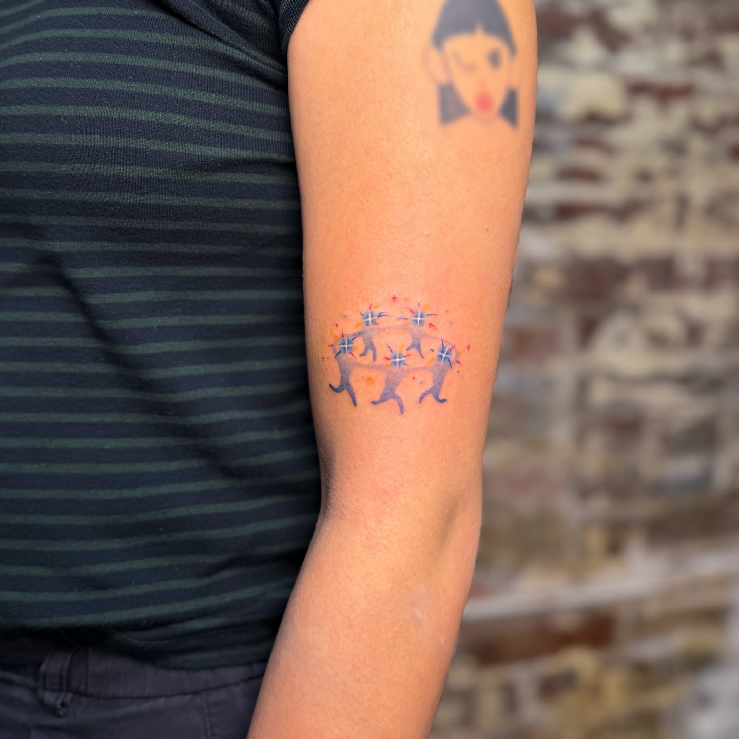 Dancing figures watercolor tattoo on the forearm by justin