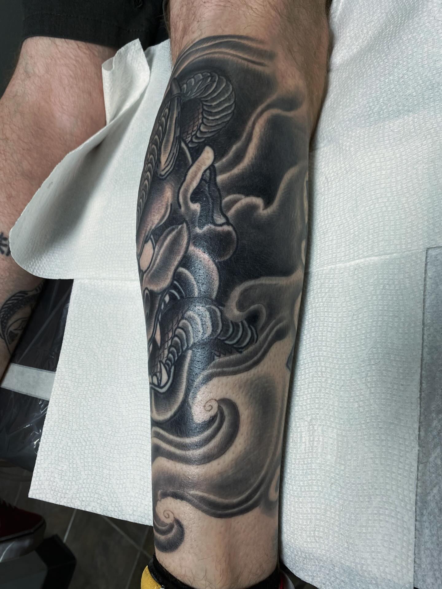 Wave and dragon japanese irezumi tattoo on the forearm by Houston tattoo artist
