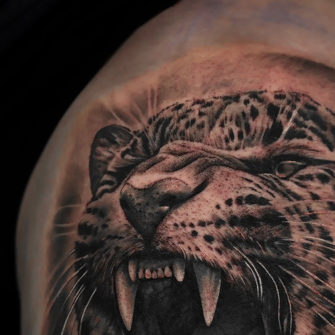 Leopard face realism tattoo on the shoulder by Felipe Andrade