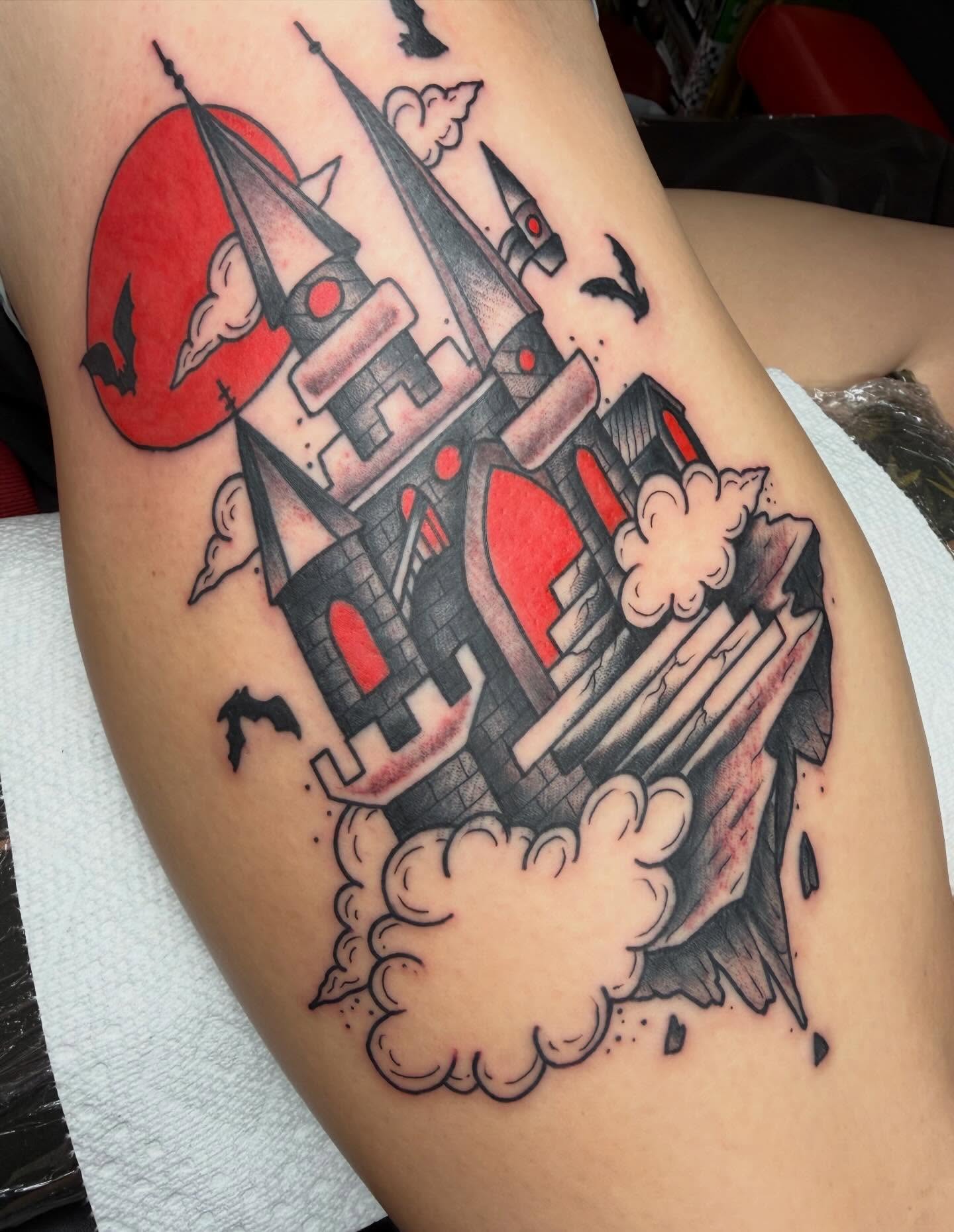 Castle American traditional tattoo on the thigh by April Morris ⚔️ Tattoo Goblin
