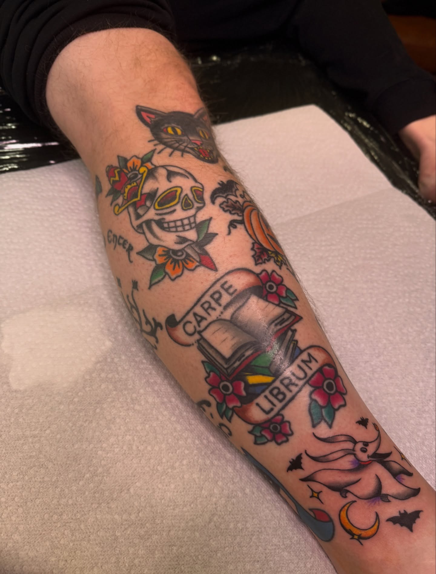Book and cat American traditional tattoo on the forearm by Ethan, Toledo, Ohio