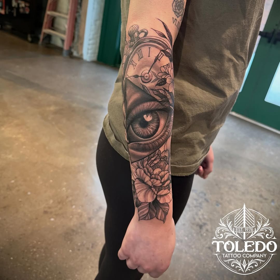 Eye, clock, and flowers realism tattoo on the forearm by Kodi Klo