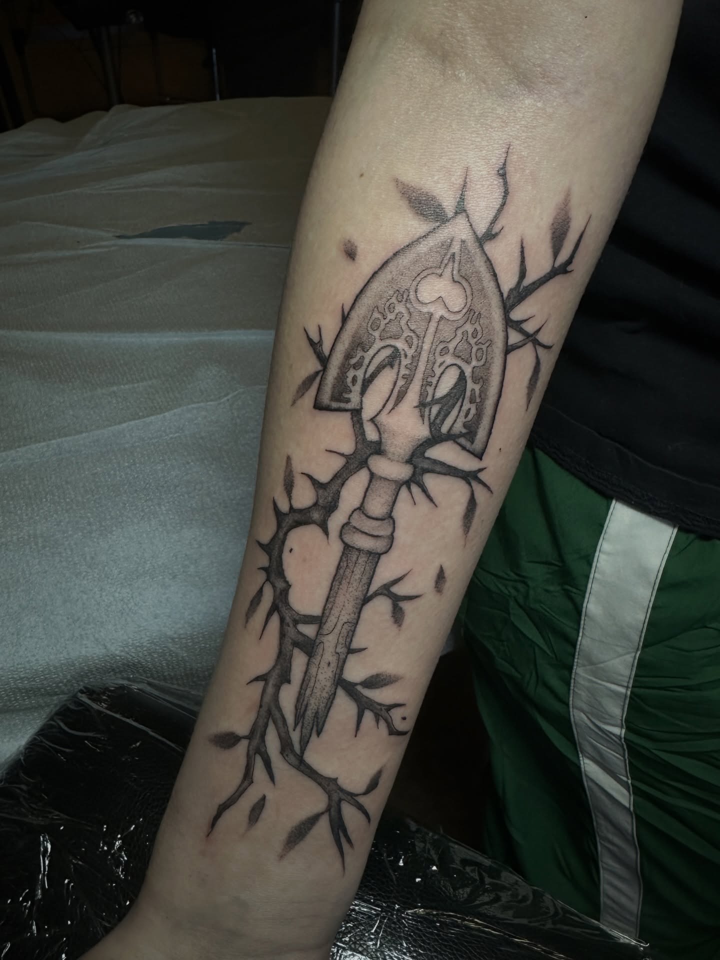 Ax and thorns black and grey tattoo on the forearm by Luisa Gonzalez, Austin, Texas