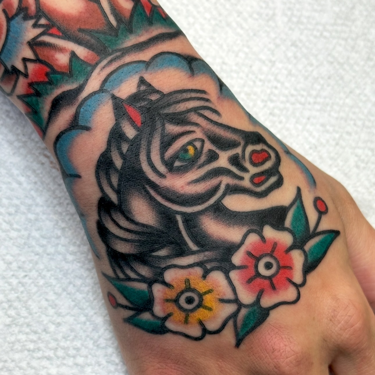 Tiger and flowers American traditional tattoo on the forearm by Amanda Bonhomme, Las Vegas, Nevada