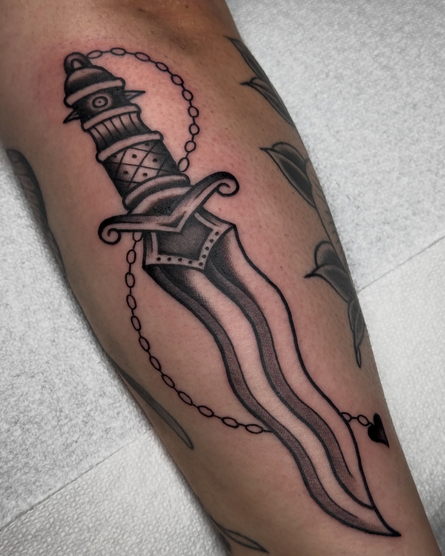 Dagger with chain black and grey tattoo on the forearm by Bre Grover, Vancouver, British Columbia