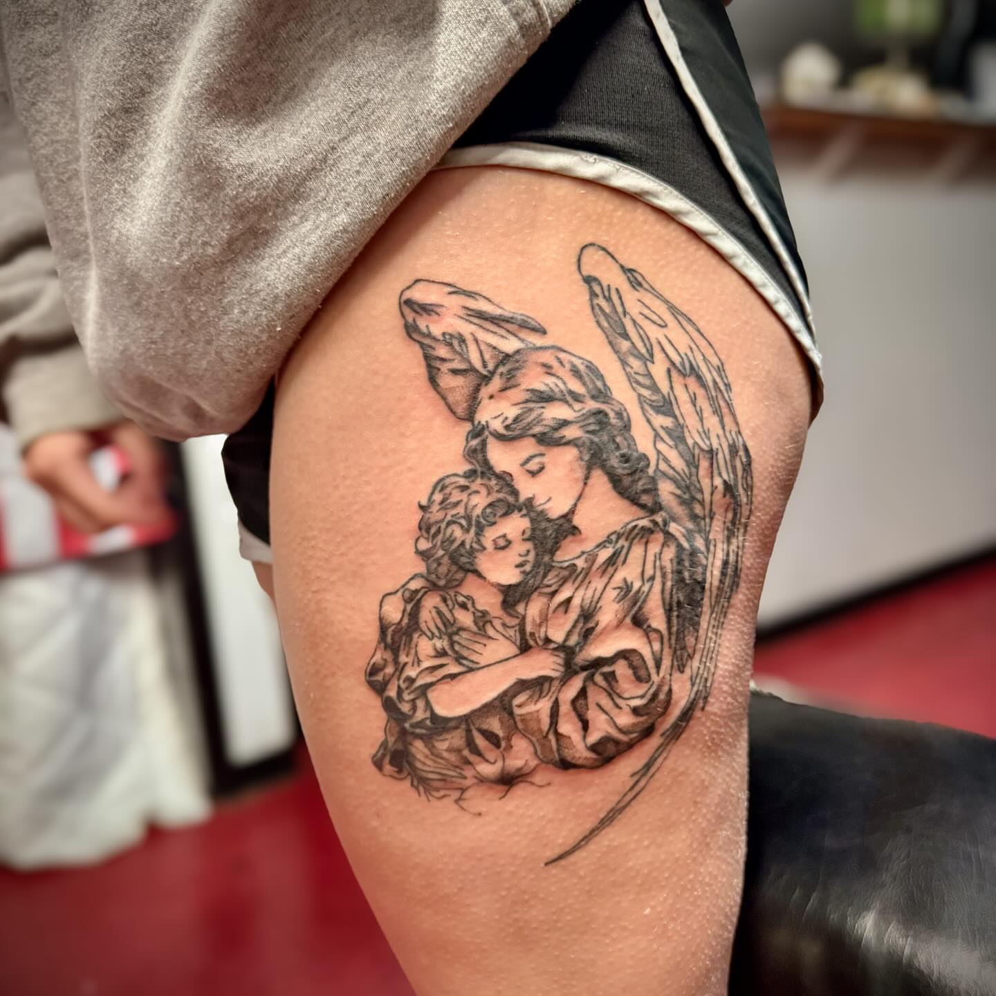 Angel and child realism tattoo on the thigh by 🪬🍄Larissa Potter🍄🪬