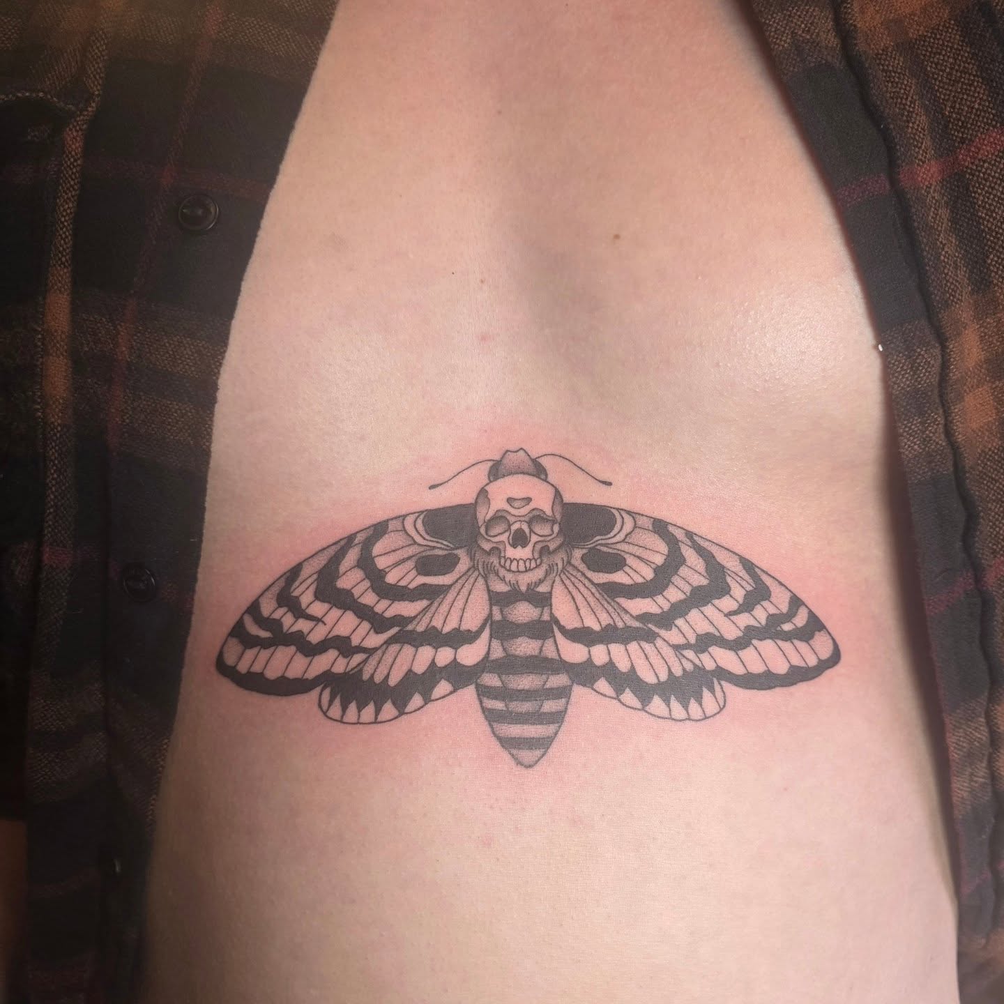 Moth with skull head black and grey tattoo on the thigh by Cassieal Welch