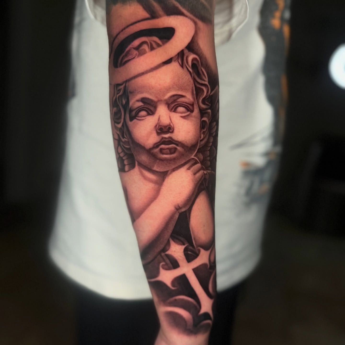 Angelic cherub realism tattoo on the forearm by Geo