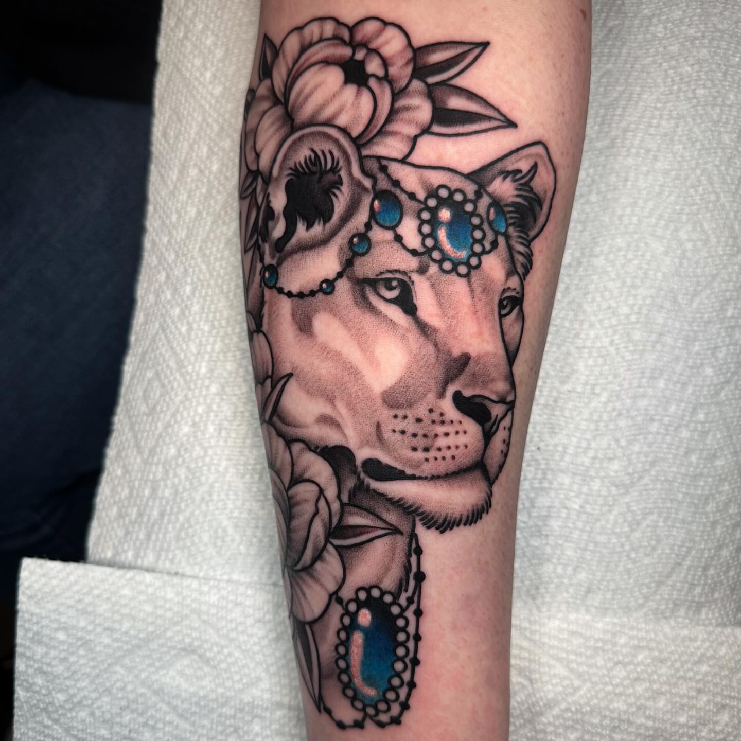 Lioness with floral crown American traditional tattoo on the forearm by Dani Johnson