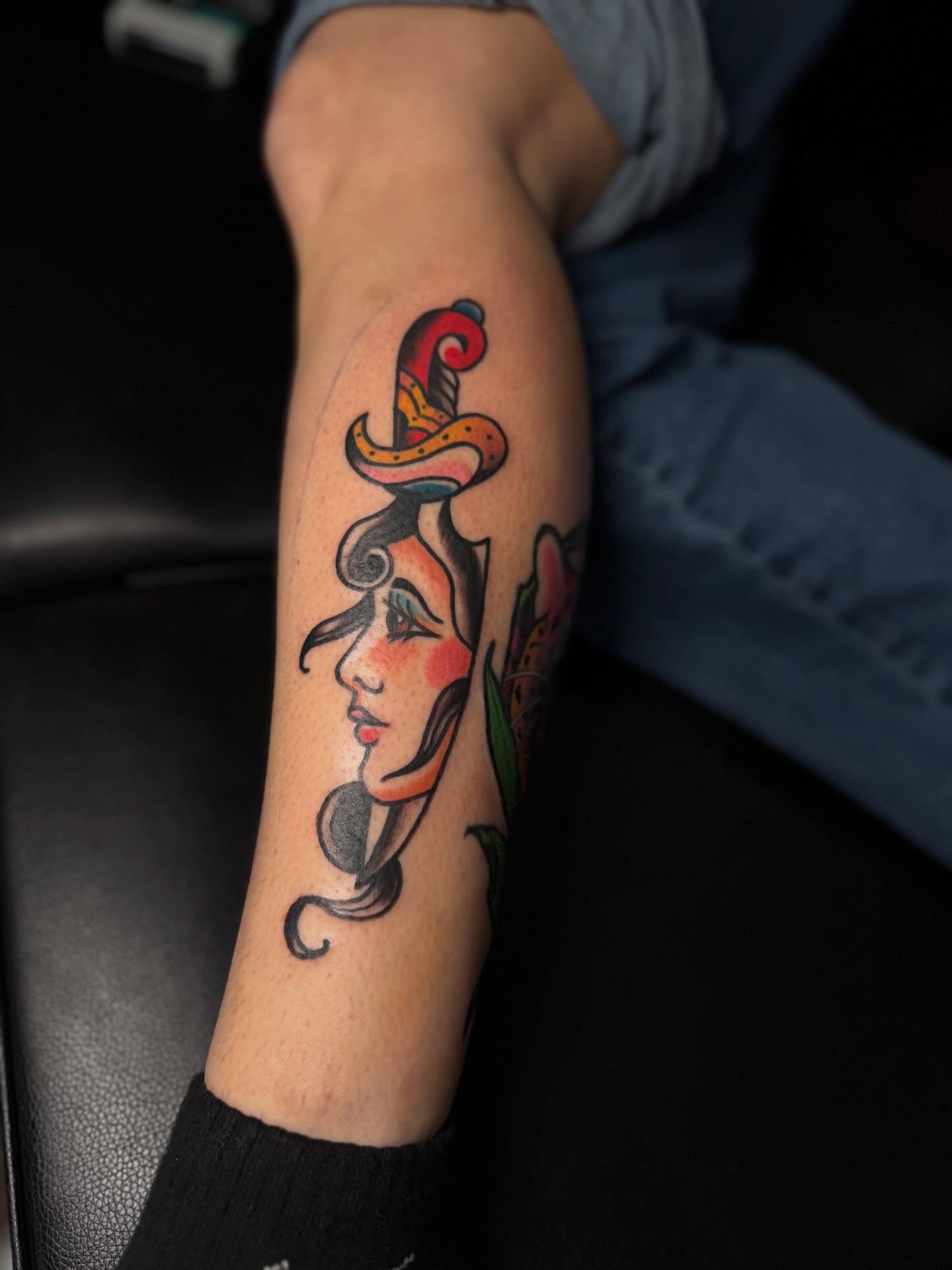 Woman's face with hat American traditional tattoo on the forearm by Robbie Roberson