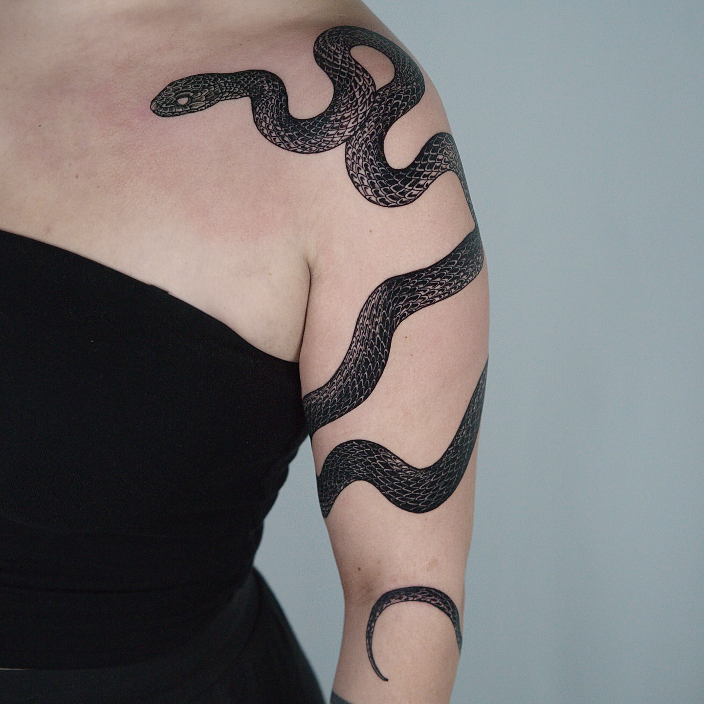 Snake black and grey tattoo on the upper arm by H I R A  L U P E - tattoo artist, Oakland, California