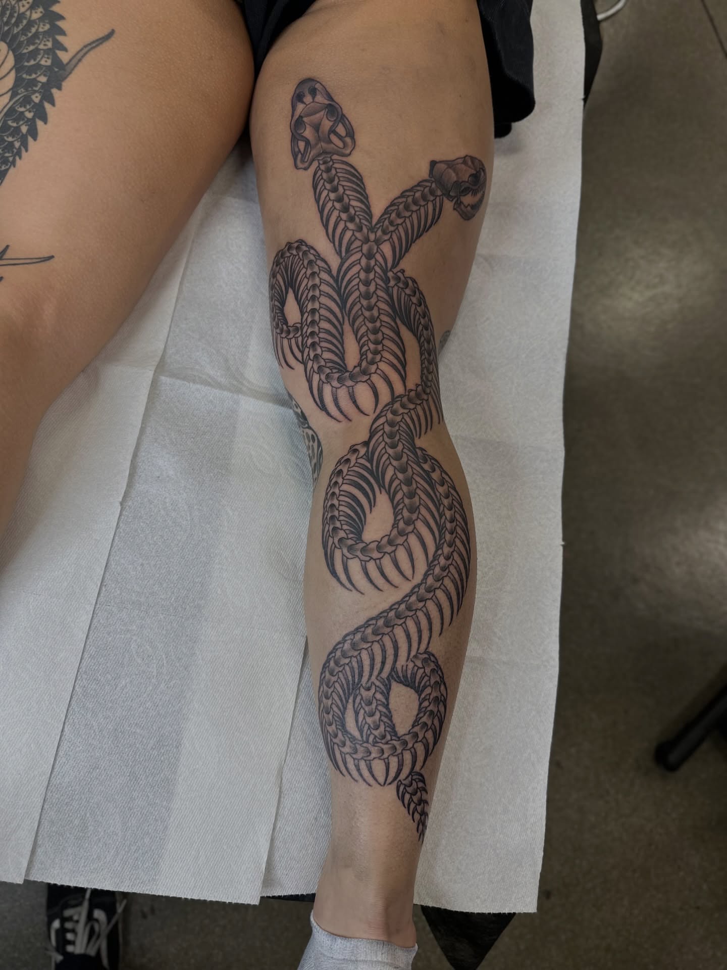 Snake black and grey tattoo on the leg by Walk-in American Traditional Tattoos Las