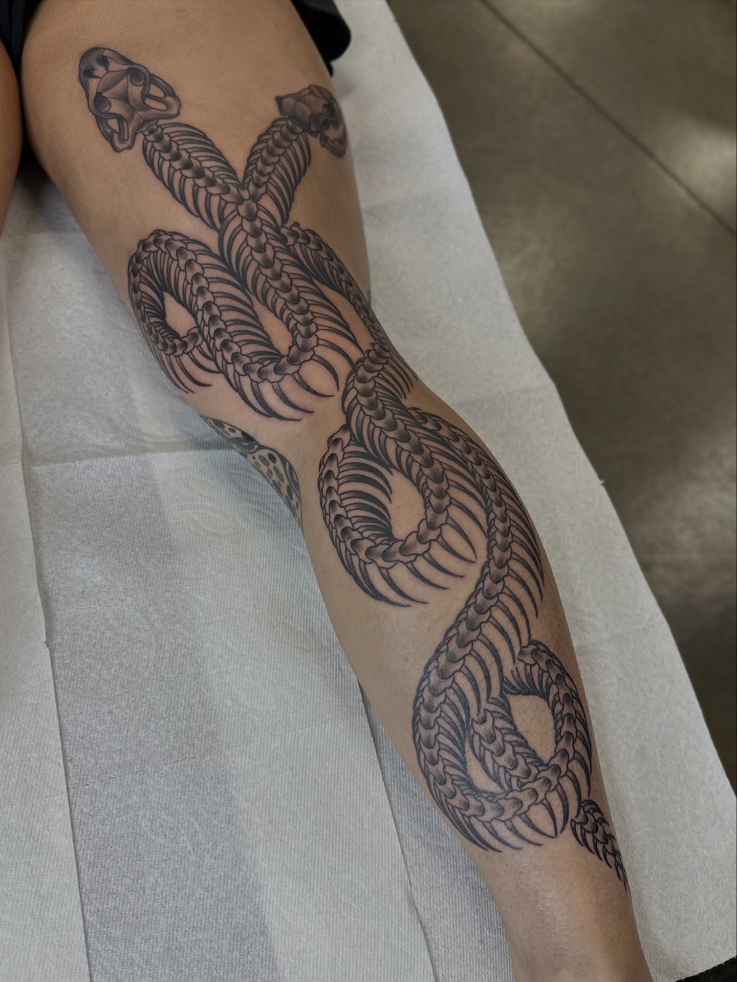 Snake black and grey tattoo on the forearm by Walk-in American Traditional Tattoos Las