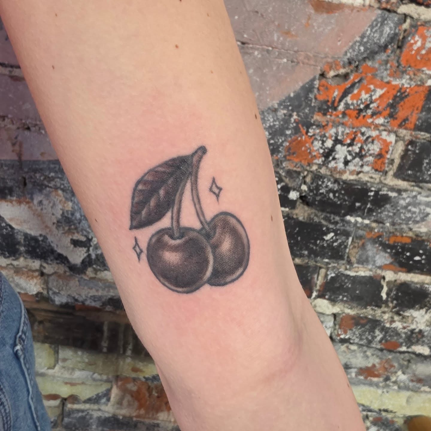 Cherries black and grey tattoo on the forearm by Tattoos by Annie