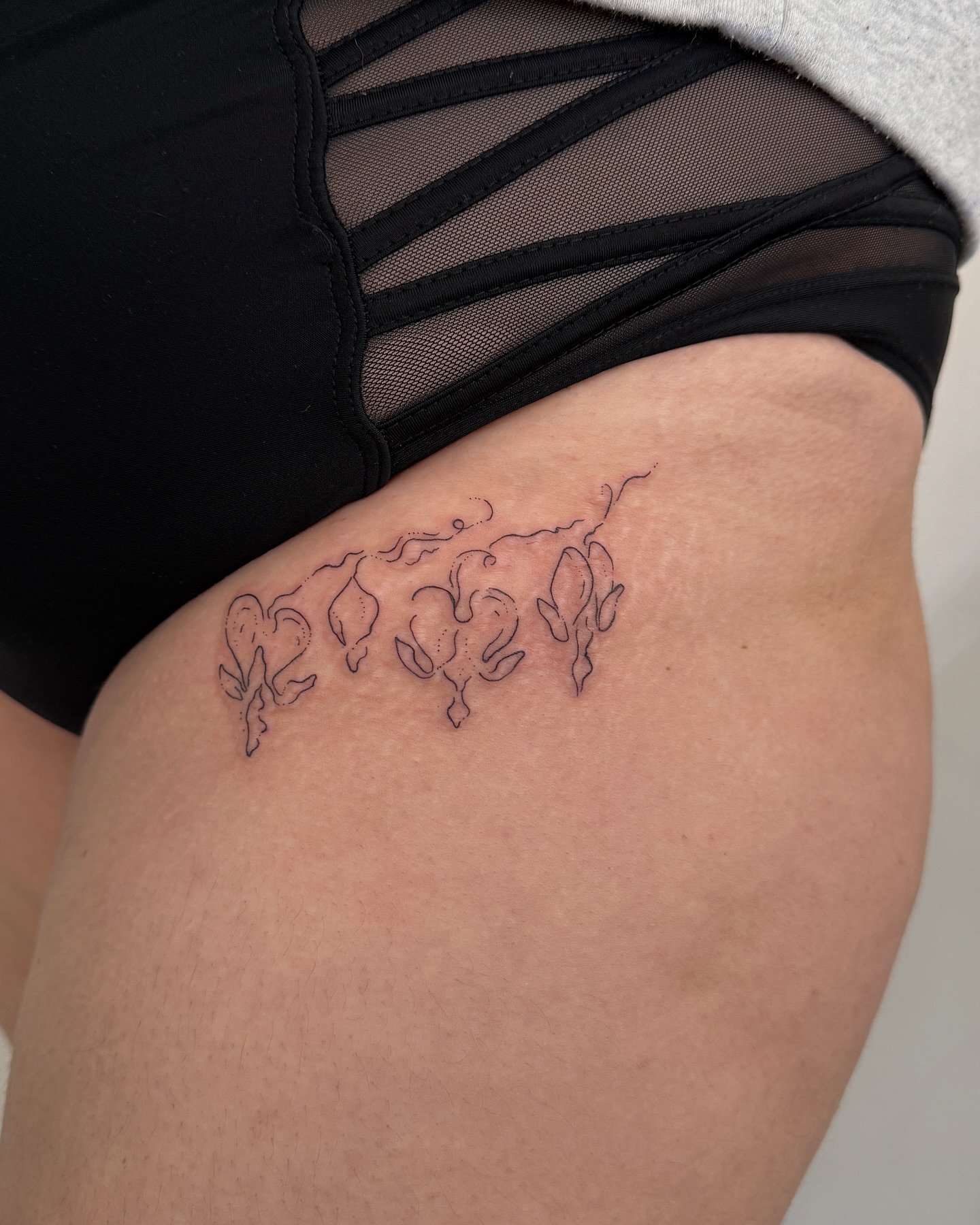 Abstract floral black and grey tattoo on the thigh by Inky Apricot, Austin, Texas