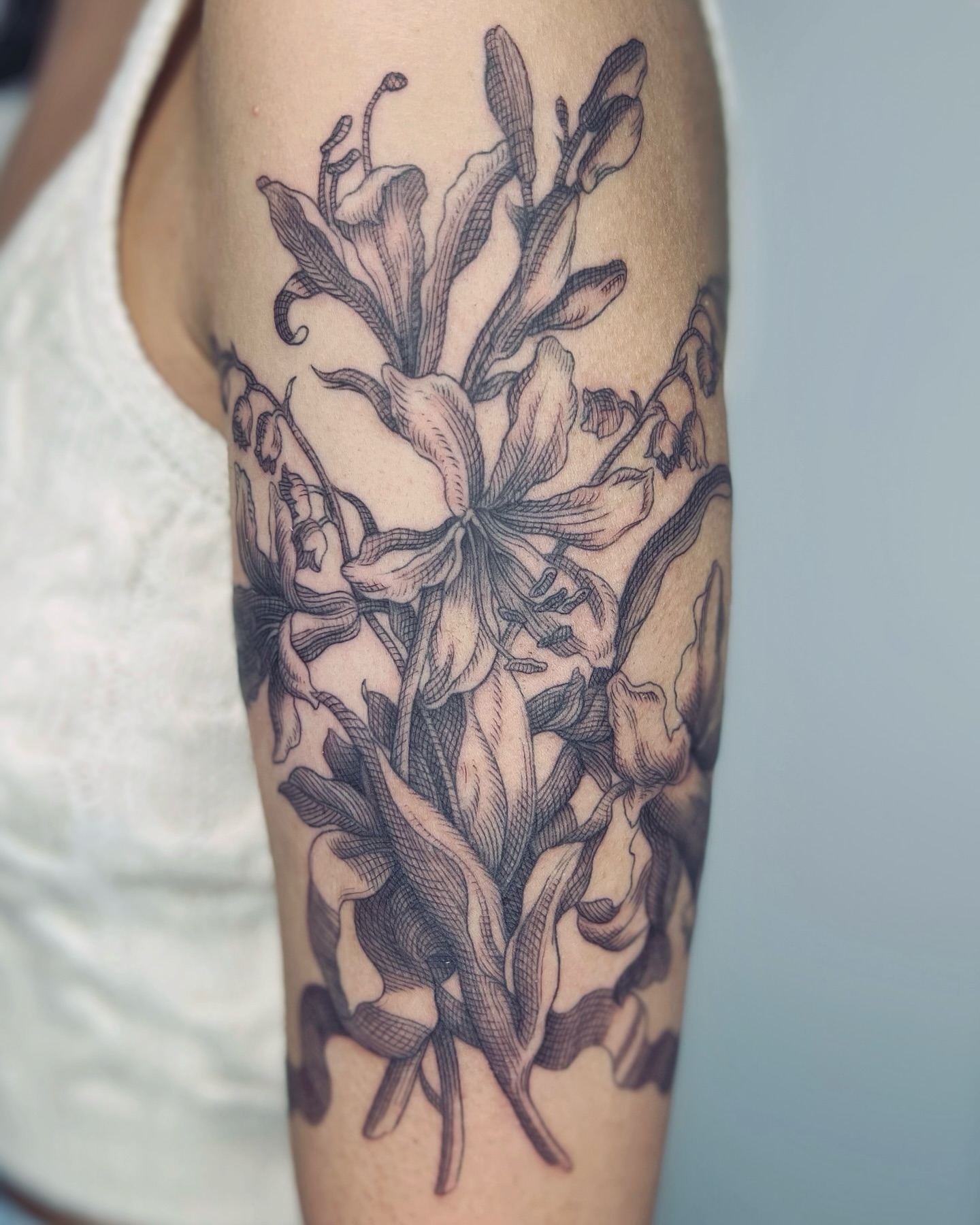 Lilies black and grey tattoo on the forearm by Jorge Nox