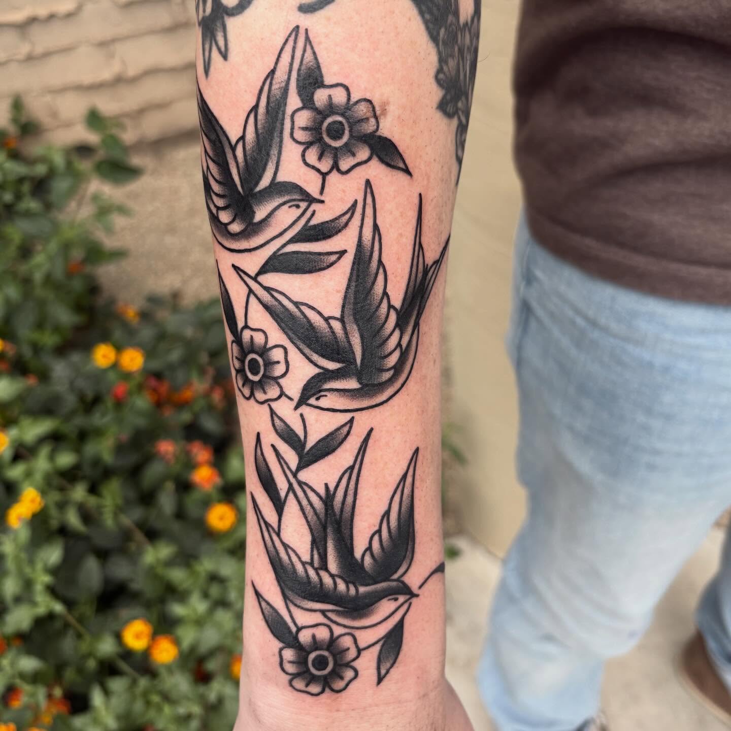 Swallows and flowers American traditional tattoo on the forearm by Allyson Monique