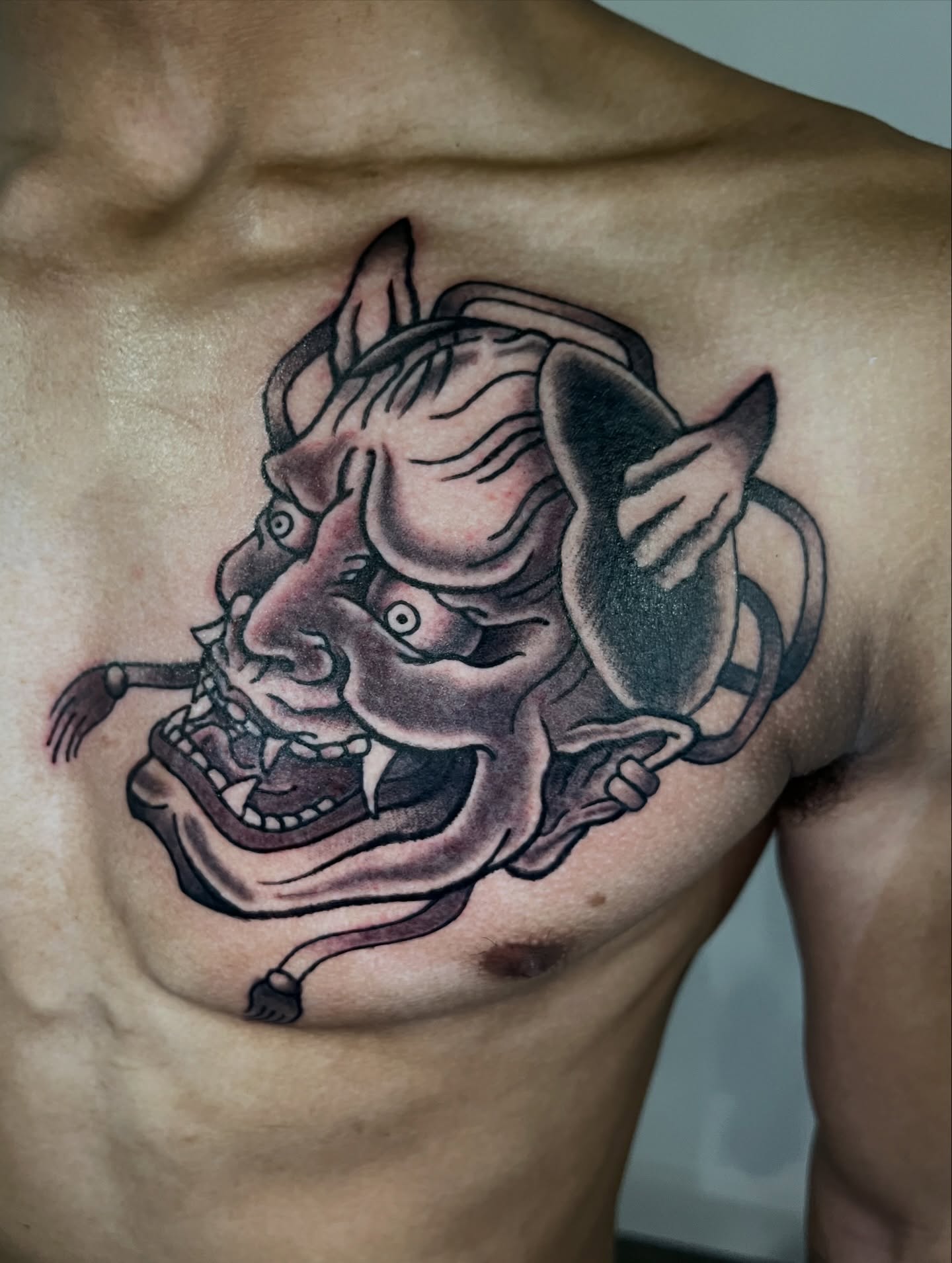 Demon mask japanese irezumi tattoo on the chest by Brian Easlon