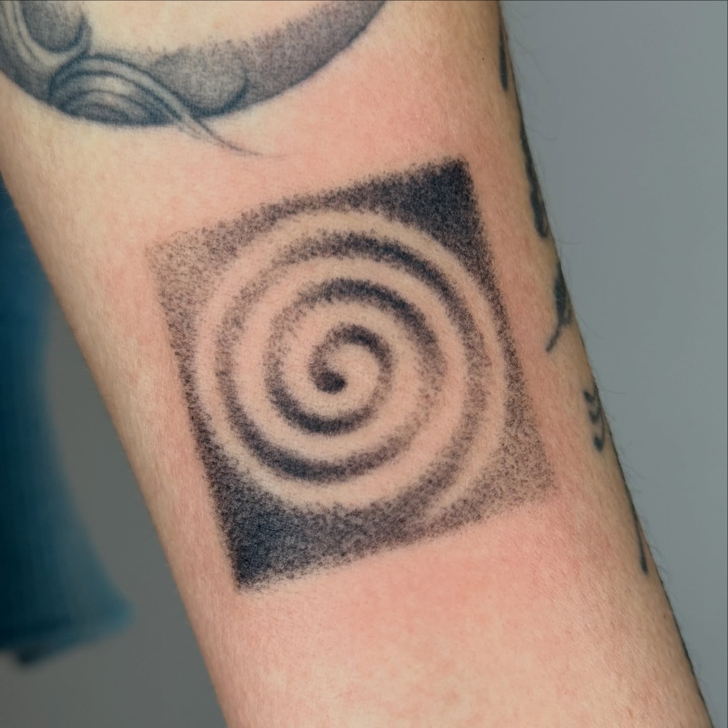 Hypnotic spiral dotwork tattoo on the forearm by Monica Reynolds