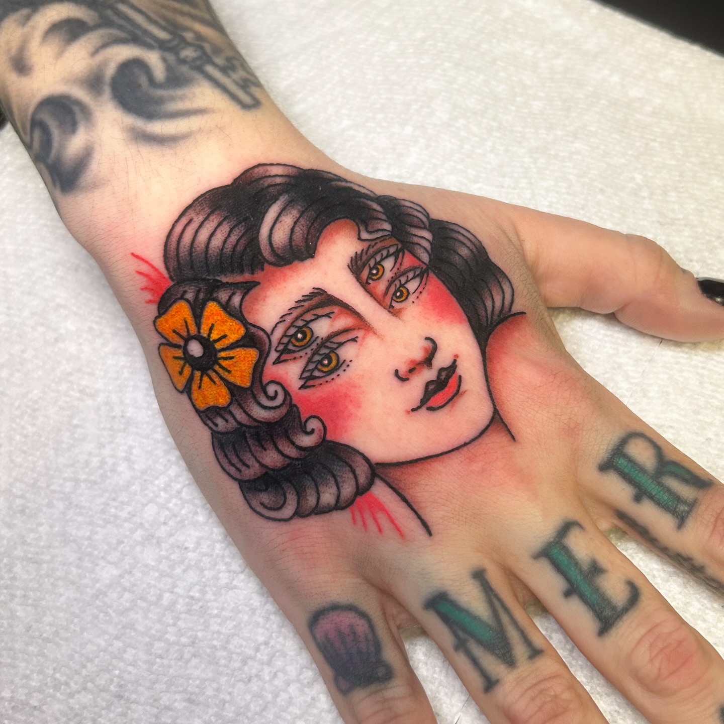Woman's face American traditional tattoo on the hand by Jessica Oram Brockman, Dayton, Ohio