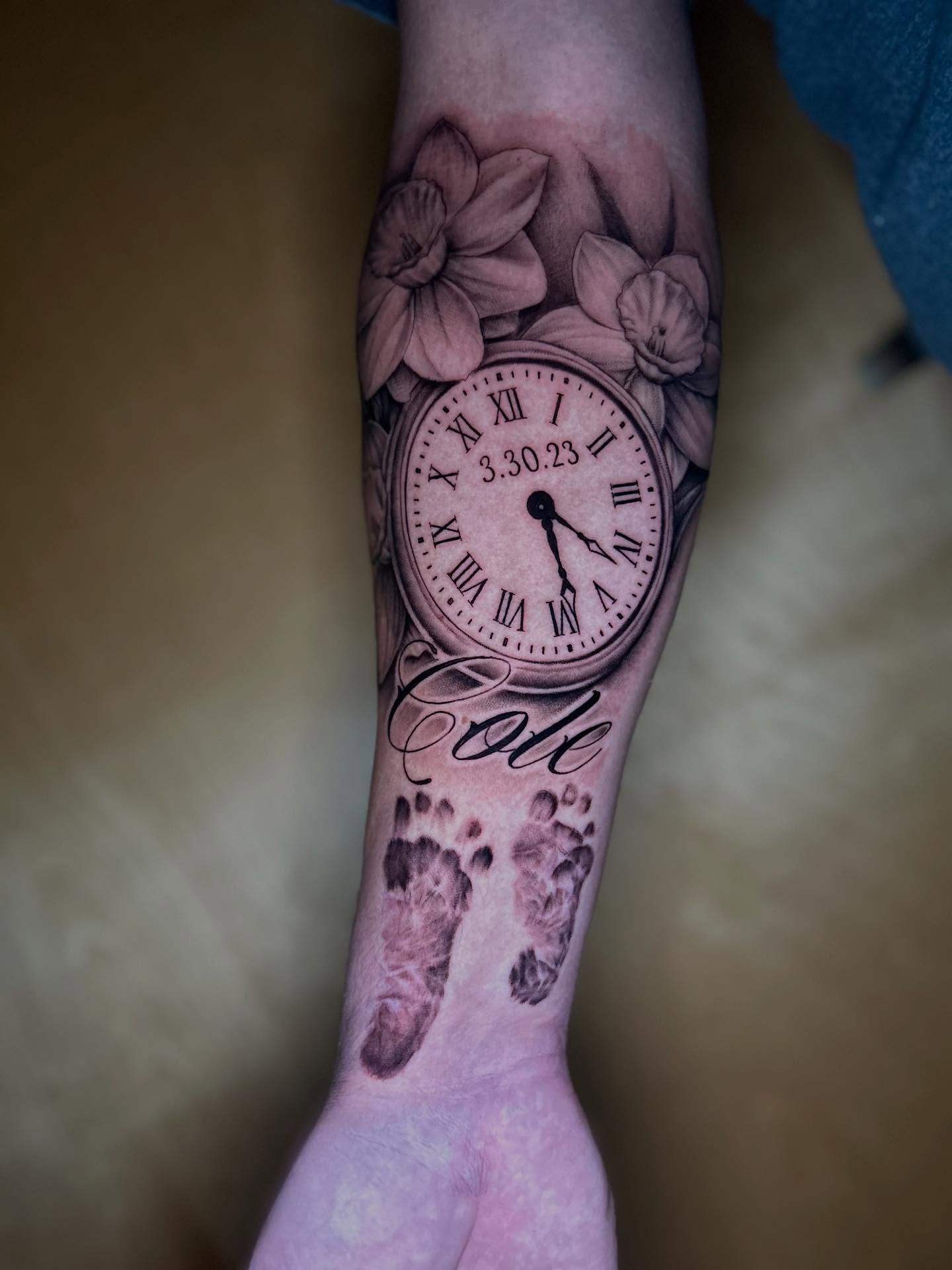 Clock with floral design realism tattoo on the forearm by Mayhem Andrews