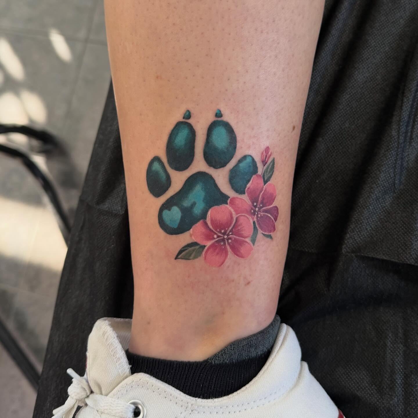 Paw print with flowers dotwork tattoo on the forearm by Babes