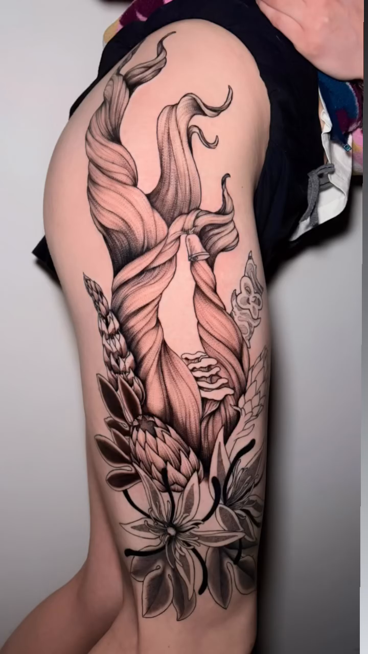 Woman with flowers dotwork tattoo on the upper arm by Kenzie Mecham-Cunningham