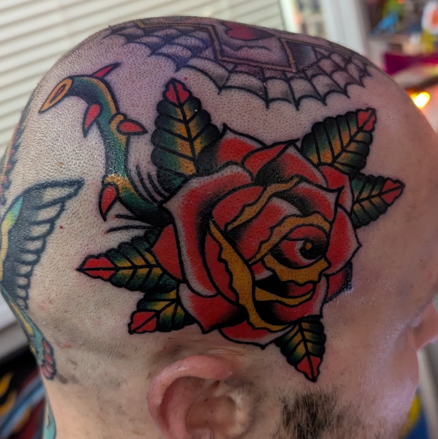 Rose and snake American traditional tattoo on the head by Ryan Slegel