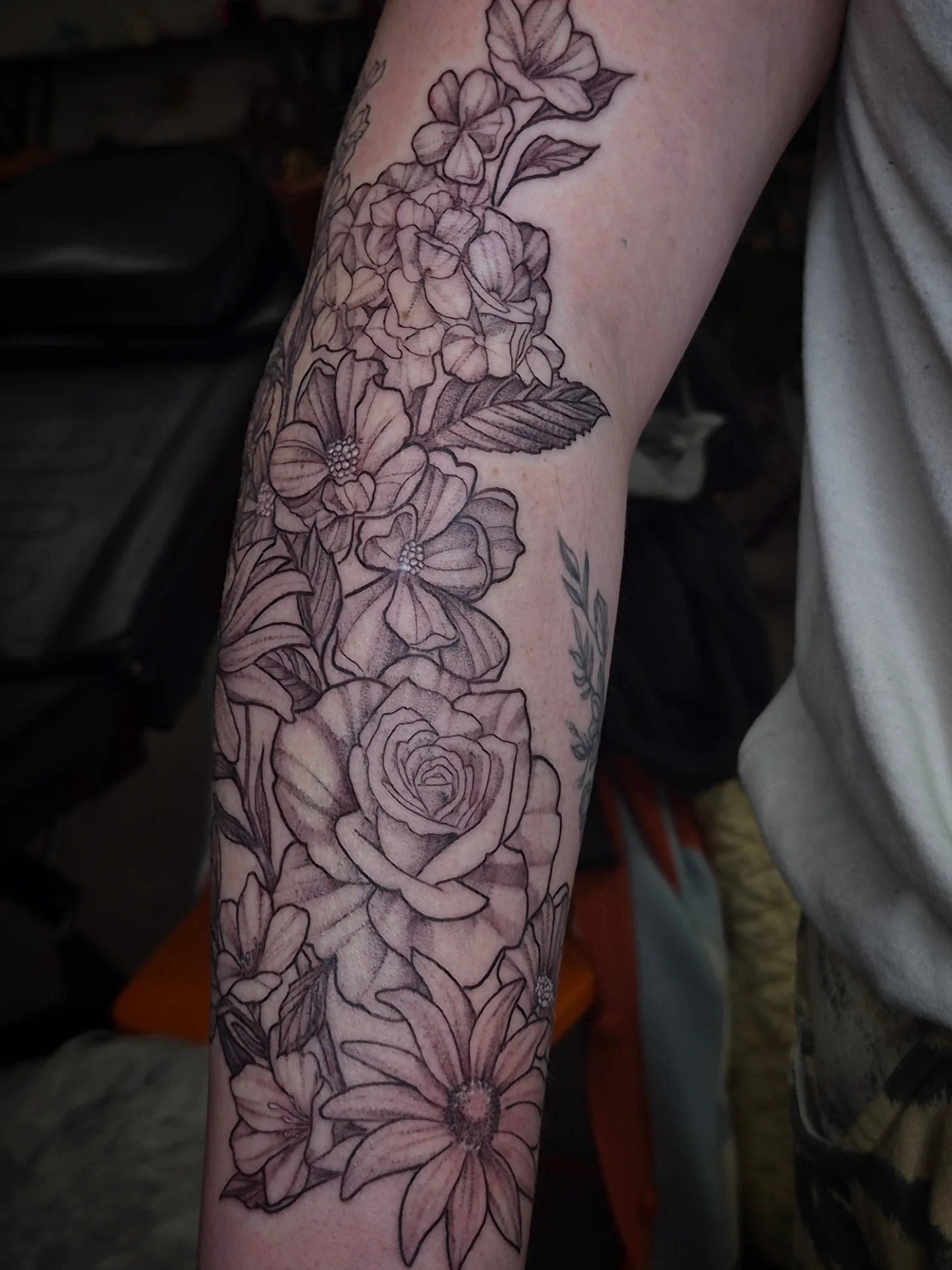Floral arrangement black and grey tattoo on the forearm by Lydia Kiley