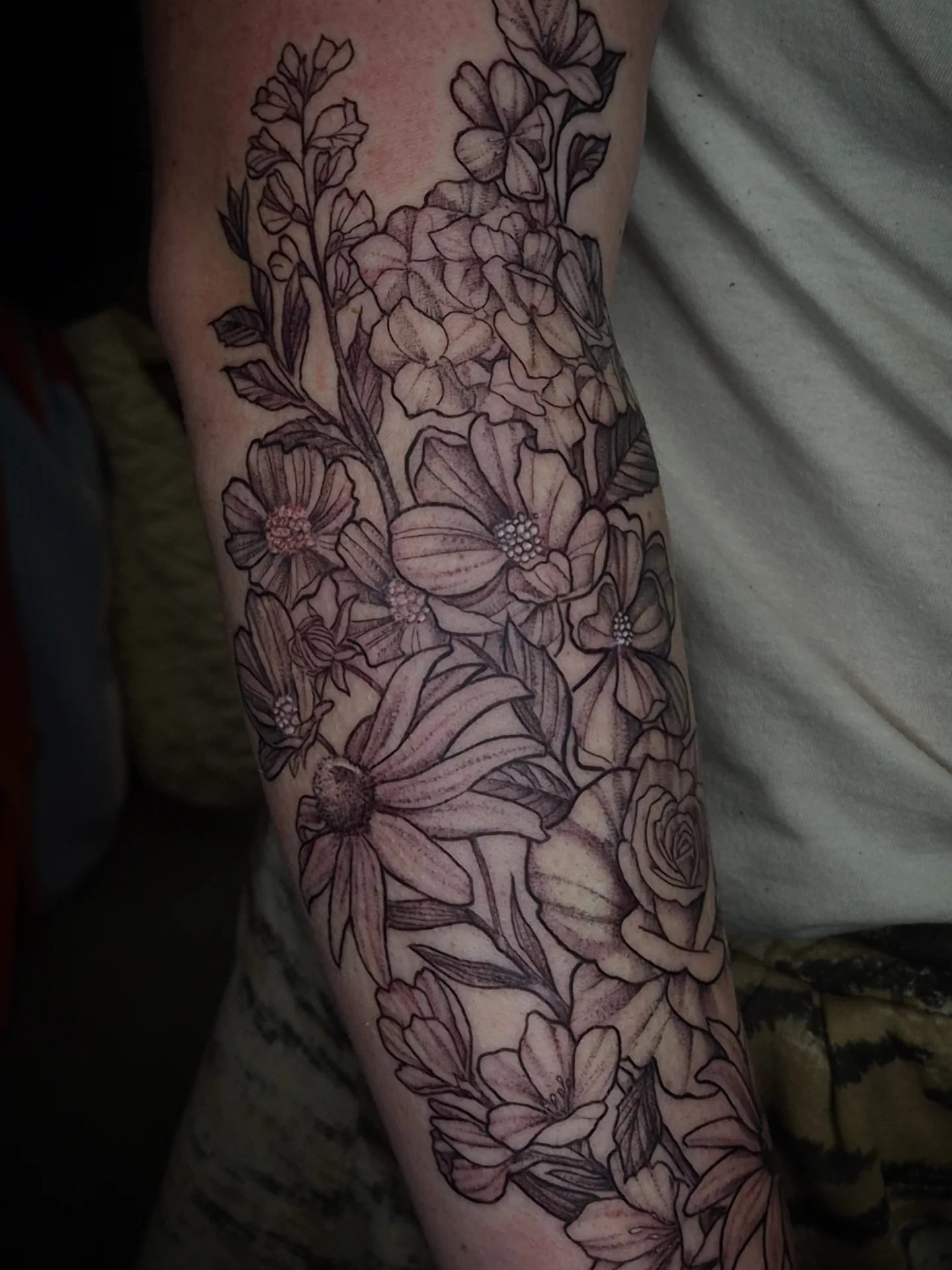 Floral bouquet black and grey tattoo on the forearm by Lydia Kiley