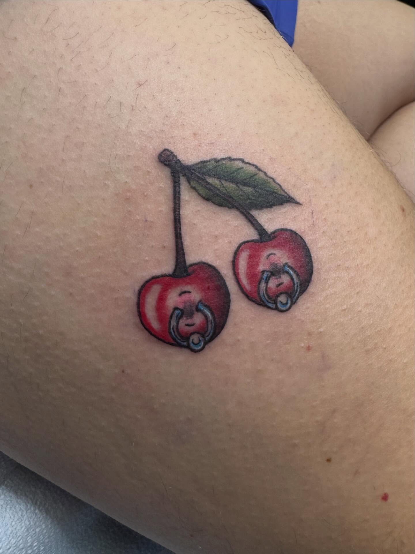 Cherries realism tattoo on the thigh by Nikki Powills