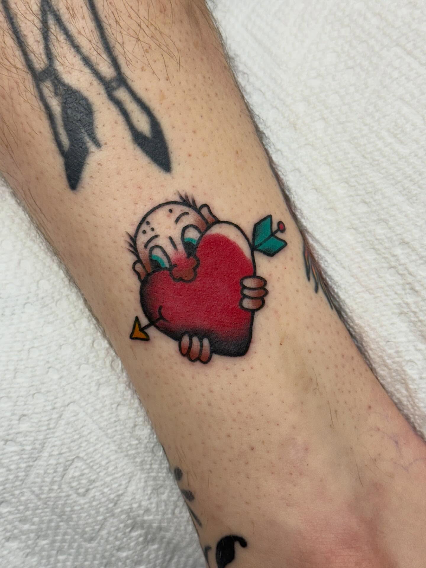 Baby hugging heart American traditional tattoo on the forearm by Ben